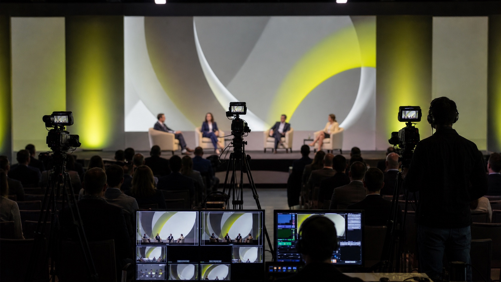 Três câmaras a captar um painel empresarial num auditório
