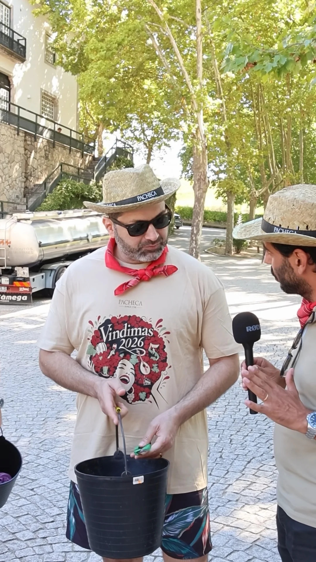 Conversa com um participante nas vindimas, com chapéu e equipamento de apanha